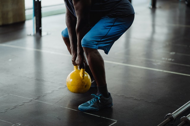 a person squatting with a kettleball