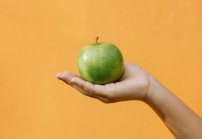 a person holding an apple